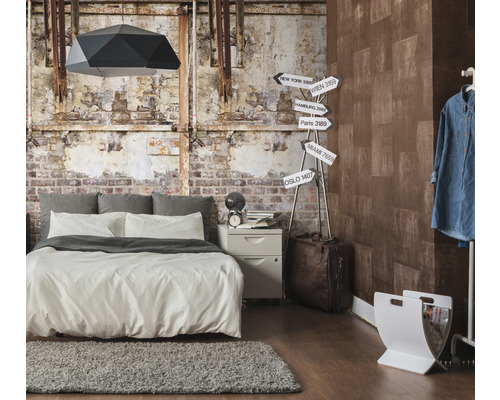 Slaapkamer met bed, nachtkastje, lamp en decoratieve wanddecoratie in industriële stijl