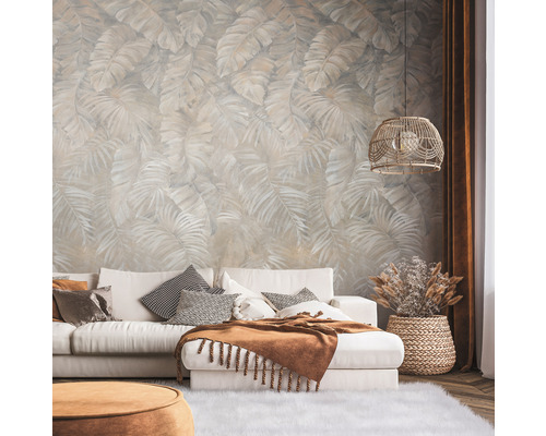 Woonkamer met behang met print, bank, kussens en lamp.