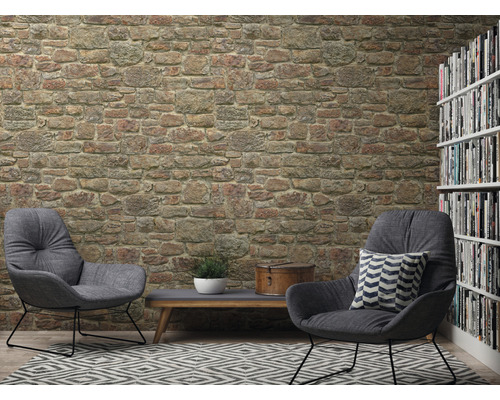 Woonkamer met stenen muurbehang, twee fauteuils, vloerkleed en boekenkast