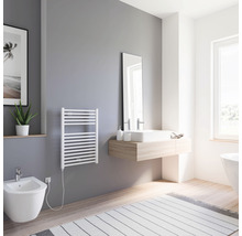 Lichte badkamer met handdoekradiator, bidet, wastafel en spiegel