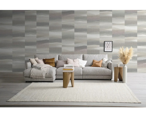 Woonkamer met bank, tapijt, bijzettafels en behang met patroon