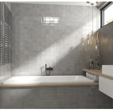Moderne badkamer met grijze tegels, ligbad en radiator