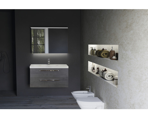 Badkamer met wastafelonderkast, spiegel met verlichting, bidet en toilet.