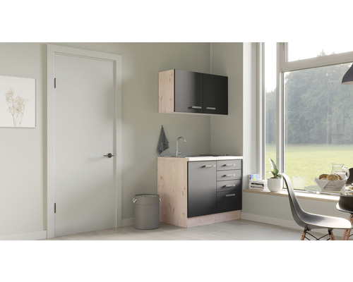 Compacte kitchenette met spoelbak, onderkast en bovenkast in een lichte ruimte met raam.