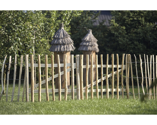 Houten hek met tuinpoort en twee bijenkorven op de achtergrond