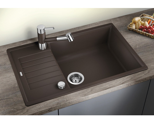 Bruine spoelbak met afdruiprek en kraan op een werkblad.