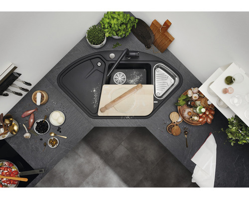 Hoekspoelbak met kraan en diverse keukengerei op een aanrecht.