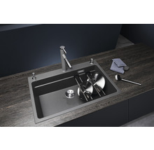 Spoelbak met afdruiprek, zeepdispenser en keukenkraan op een werkblad