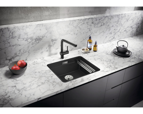 Zwarte gootsteen met kraan op marmeren aanrecht in een keuken.