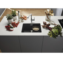 Keukenspoelbak met kraan en diverse voedingsmiddelen op het aanrecht