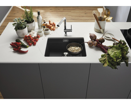 Composiet gootsteen met kraan en verse ingrediënten op het aanrecht