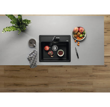 Bovenaanzicht van een spoelbak met kraan en fruitschaal op een werkblad.