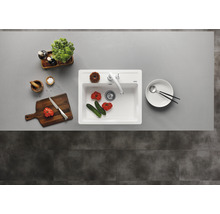 Keuken spoelbak met kraan, snijplank, servies en levensmiddelen op een werkblad