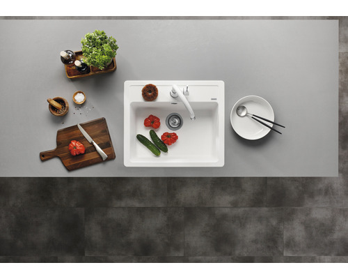 Keuken spoelbak met kraan, snijplank, servies en levensmiddelen op een werkblad