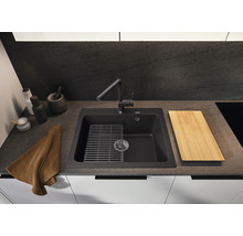 Spoelbak met afdruiprek, snijplank en kraan in een keukenomgeving