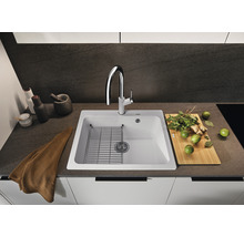 Keukenspoelbak met afdruiprek, kraan en diverse keukengerei op een werkblad