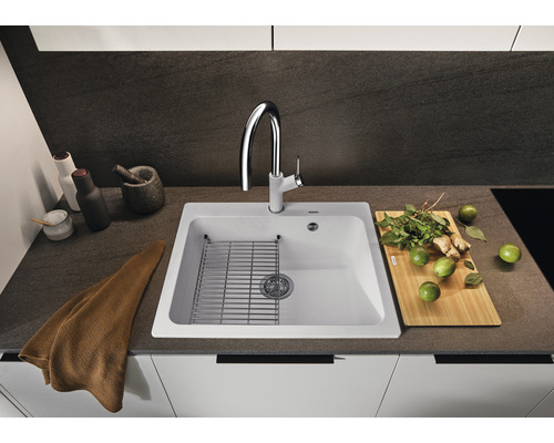 Keukenspoelbak met afdruiprek, kraan en diverse keukengerei op een werkblad