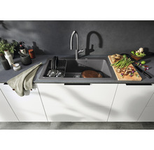 Keukenscène met spoelbak, kraan, servies en voedsel op een aanrecht