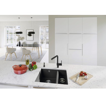 Lichte keuken met spoelbak, kraan, kookpan en eettafel