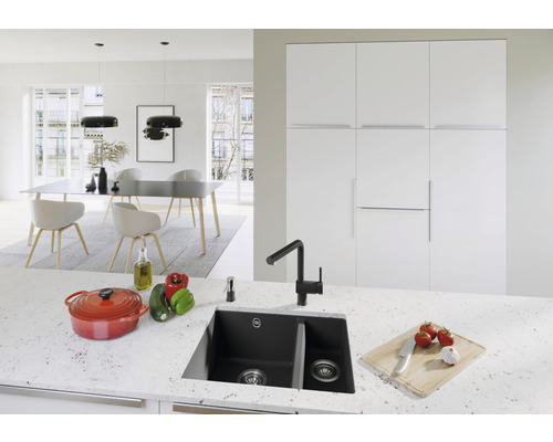 Lichte keuken met spoelbak, kraan, kookpan en eettafel