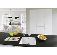 Licht interieur met spoelbak, kraan, werkblad en eetgedeelte.