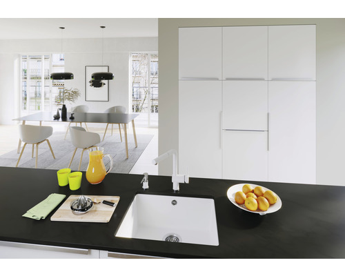 Licht interieur met spoelbak, kraan, werkblad en eetgedeelte.