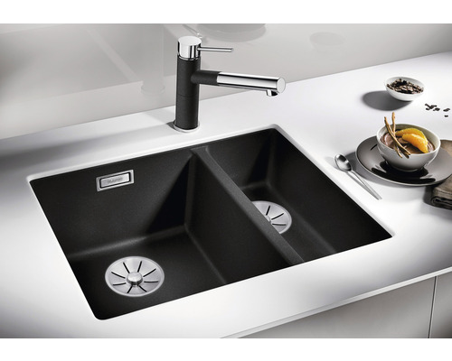 Dubbele spoelbak van graniet met kraan en etenswaren