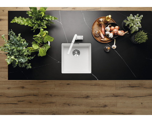 Keukenscène met gootsteen, kraan, kruiden, uien en houten vloer