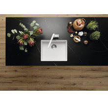 Bovenaanzicht van een keuken met een spoelbak, kraan, bloemen, kruiden en specerijen op een werkblad