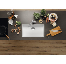 Keukenscène met spoelbak, kraan, kookplaat en keukengerei op een aanrecht