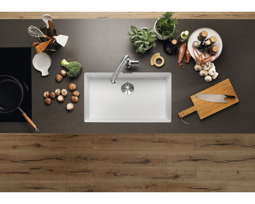 Keuken spoelbak met kraan en diverse keukengerei op een werkblad