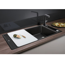 Keuken spoelbak met snijplank, kraan en zeepdispenser in een heldere en georganiseerde keuken