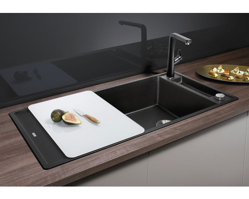 Keuken spoelbak met snijplank, kraan en zeepdispenser in een heldere en georganiseerde keuken