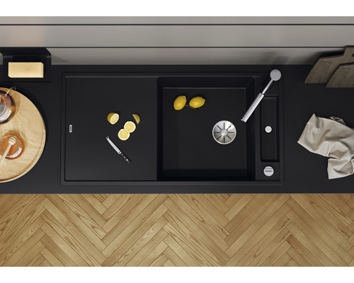 Zwarte spoelbak met afdruiprek, kraan en citroen