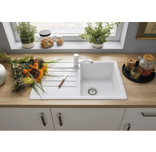 Keuken spoelbak met kraan, bloemen en keukengerei op een aanrecht