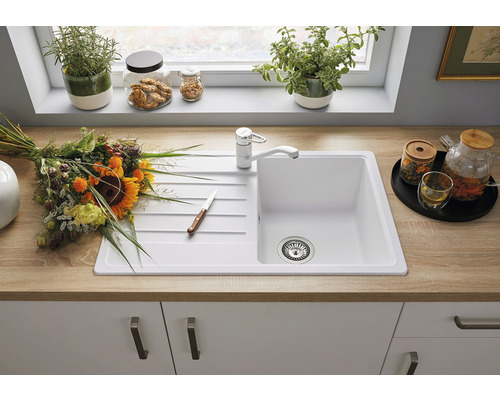 Keuken spoelbak met kraan, bloemen en keukengerei op een aanrecht