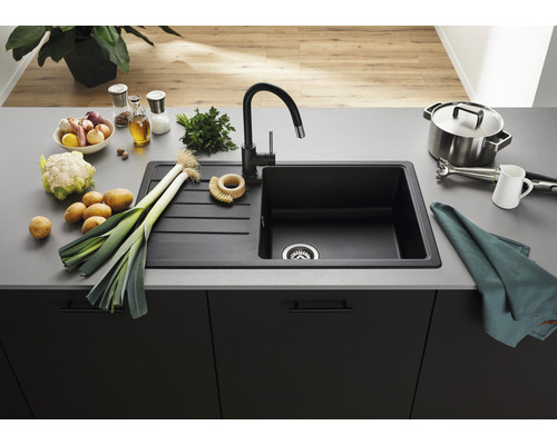 Keukenscène met spoelbak, kraan en diverse voedingsmiddelen op een aanrecht