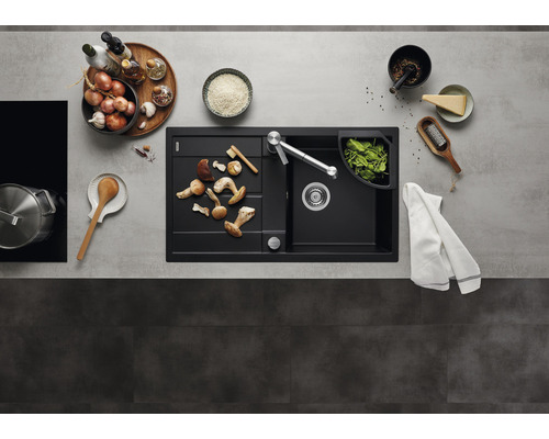 Keuken spoelbak met afdruiprek, kraan en levensmiddelen op een werkblad.