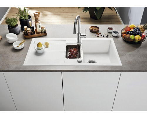 Spoelbak met afdruiprek, spoelbak en keukenkraan op een aanrecht met voedingsmiddelen