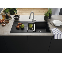 Spoelbak van composietmateriaal met afdruiprek, gootsteen en kraan in een keukenomgeving.