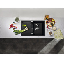 Composiet spoelbak met afdruiprek en keukenkraan, omringd door voedsel op een aanrecht.