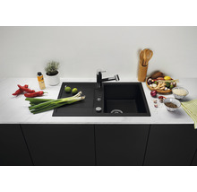 Zwarte gootsteen met kraan op een aanrecht met levensmiddelen