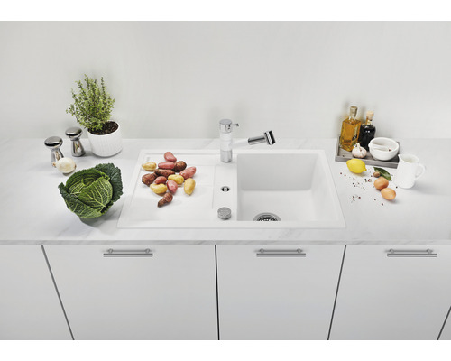 Keukenscène met spoelbak, kraan en groenten op een aanrecht