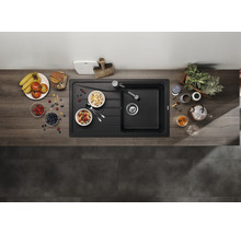 Bovenaanzicht van een moderne, zwarte gootsteen met ontbijtingrediënten op een houten aanrechtblad