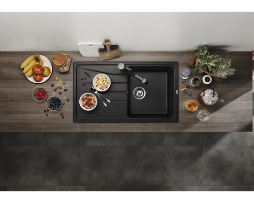 Bovenaanzicht van een moderne, zwarte gootsteen met ontbijtingrediënten op een houten aanrechtblad