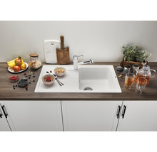 Keuken spoelbak met afdruiprek, kraan en decoratieve levensmiddelen op een aanrecht