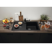 Spoelbak met afdruiprek, kraan, ontbijtingrediënten en thee op een aanrecht