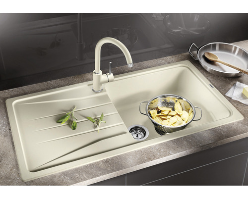 Spoelbak met afdruiprek, keukenkraan en etensresten in een zeef