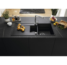 Spoelbak met afdruiprek op een aanrechtblad met voedingswaren en keukengerei