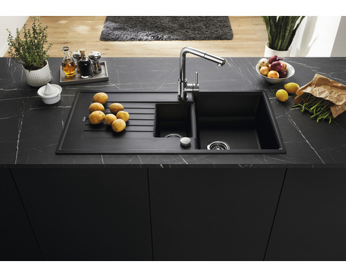 Spoelbak met afdruiprek op een aanrechtblad met voedingswaren en keukengerei